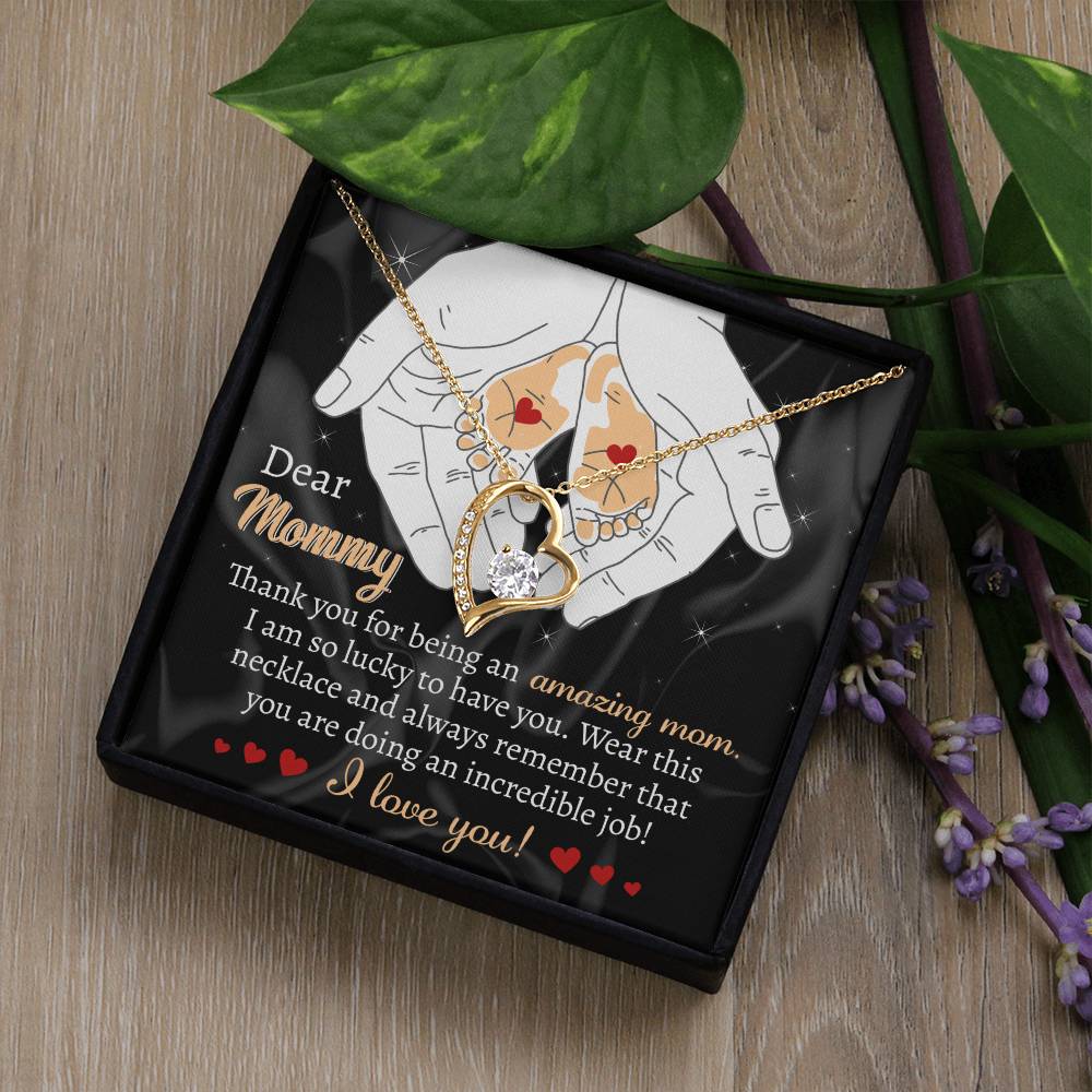 A wonderful personalized gift, the "To Mom To Be, An Incredible Job - Forever Love Necklace," is a stunning piece featuring a heart and crystal pendant in white gold. It comes beautifully displayed in a black box with floral decorations and a heartfelt message: "Dear Mommy, Thank you for being an amazing mom...