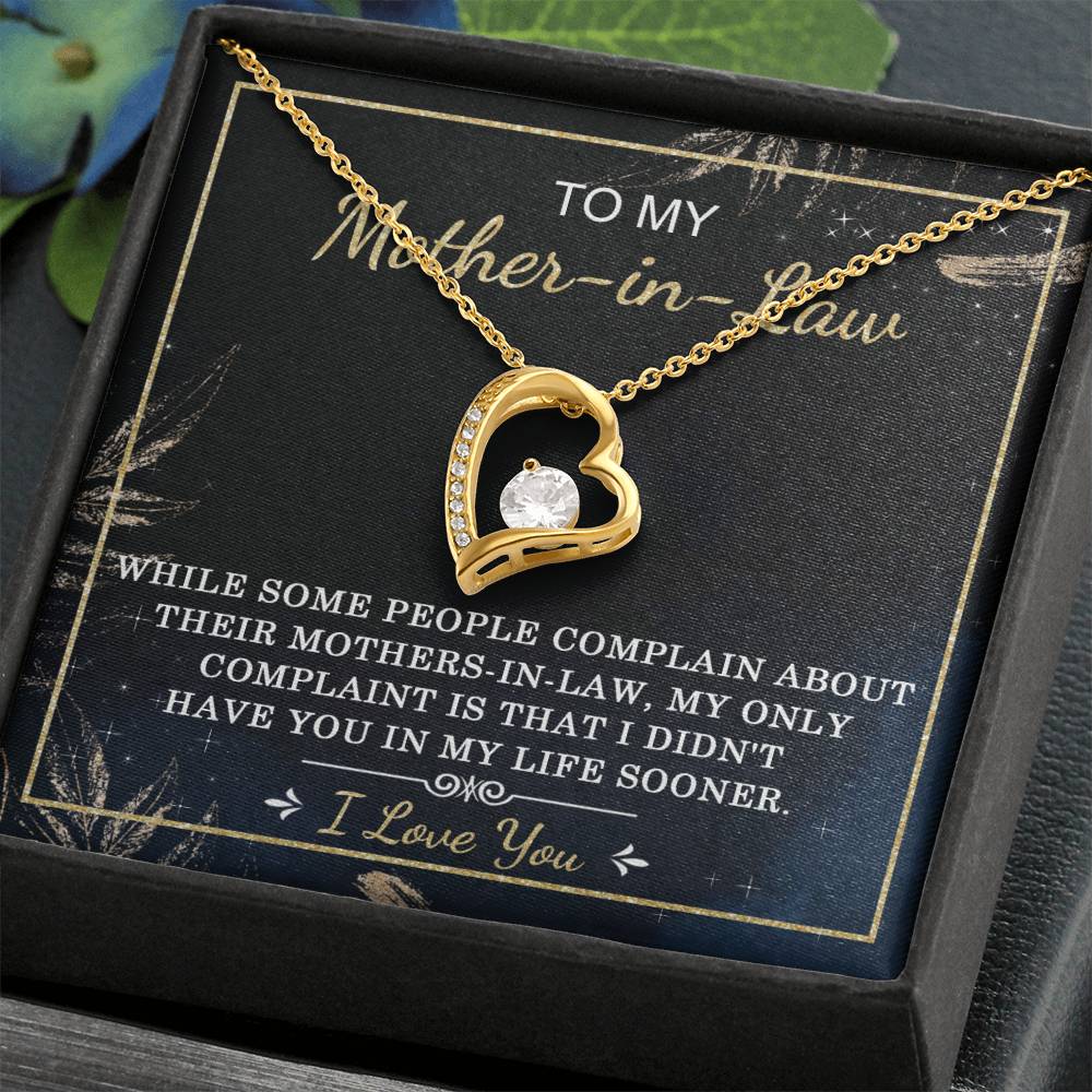 A heart-shaped "To Mother-In-Law, In My Life - Forever Love Necklace" with a central clear cubic zirconia stone is displayed in a box, featuring a message to a mother-in-law expressing love and appreciation.