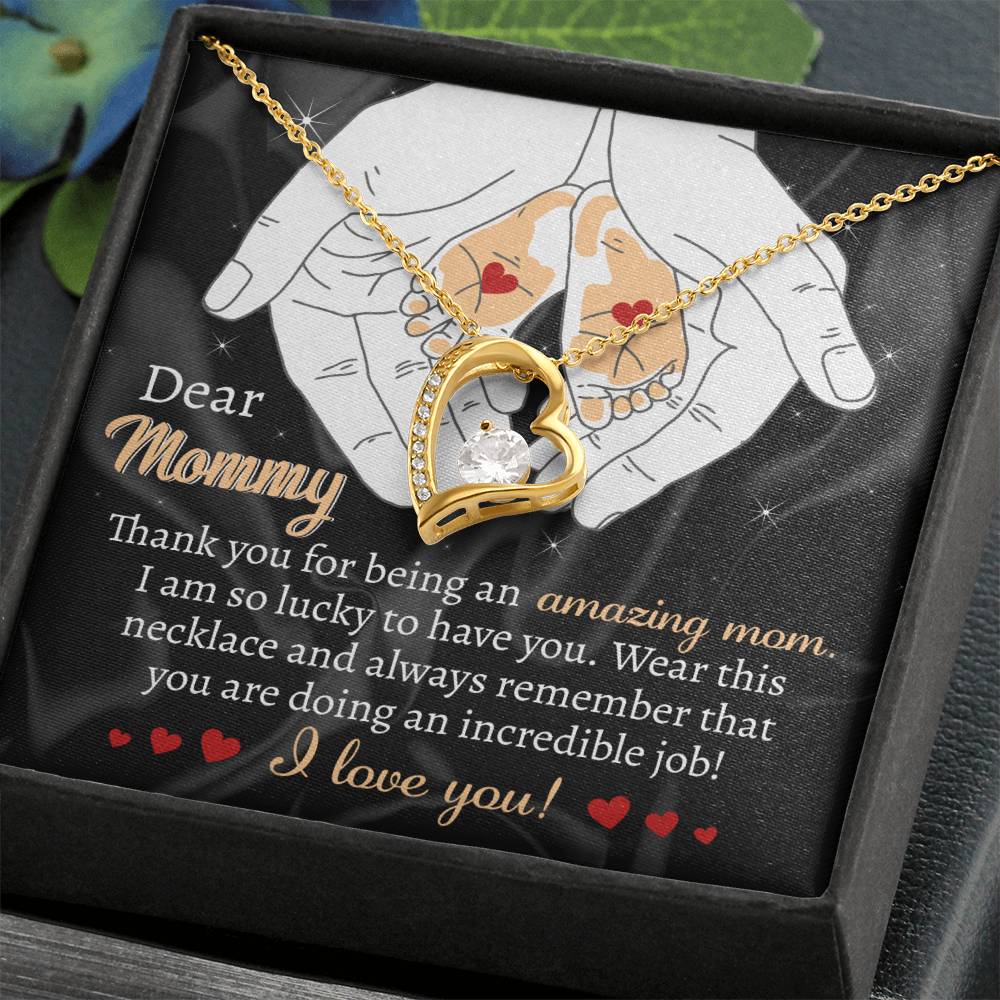 The "To Mom To Be, An Incredible Job - Forever Love Necklace" showcases a beautiful gold heart pendant that rests on a card with a heartfelt message to a mother, conveying gratitude and love. This personalized gift is exquisitely presented in an elegant decorative black box.