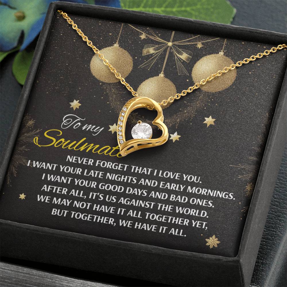 The Soulmate-Have It All - Forever Love Necklace is a gold heart-shaped pendant featuring a central CZ crystal, elegantly displayed in a black box, accompanied by a note in the background that shares a touching message about love and togetherness.