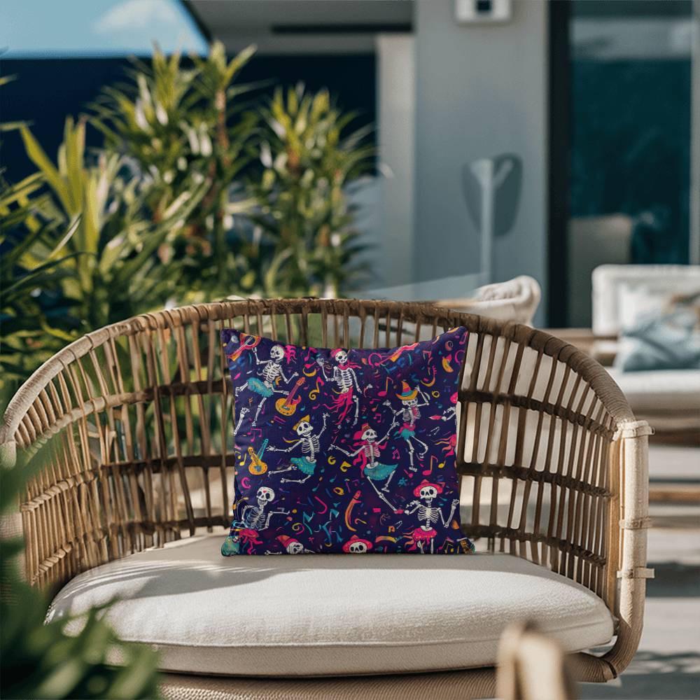 A rattan chair with a Dancing Skeleton Pillow, perfect for Halloween and mystical home decor enthusiasts, is placed on a patio, surrounded by greenery.