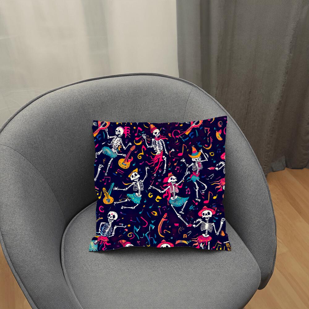 A Dancing Skeleton Pillow, featuring vibrant skeletons on a dark background, rests on a gray chair.