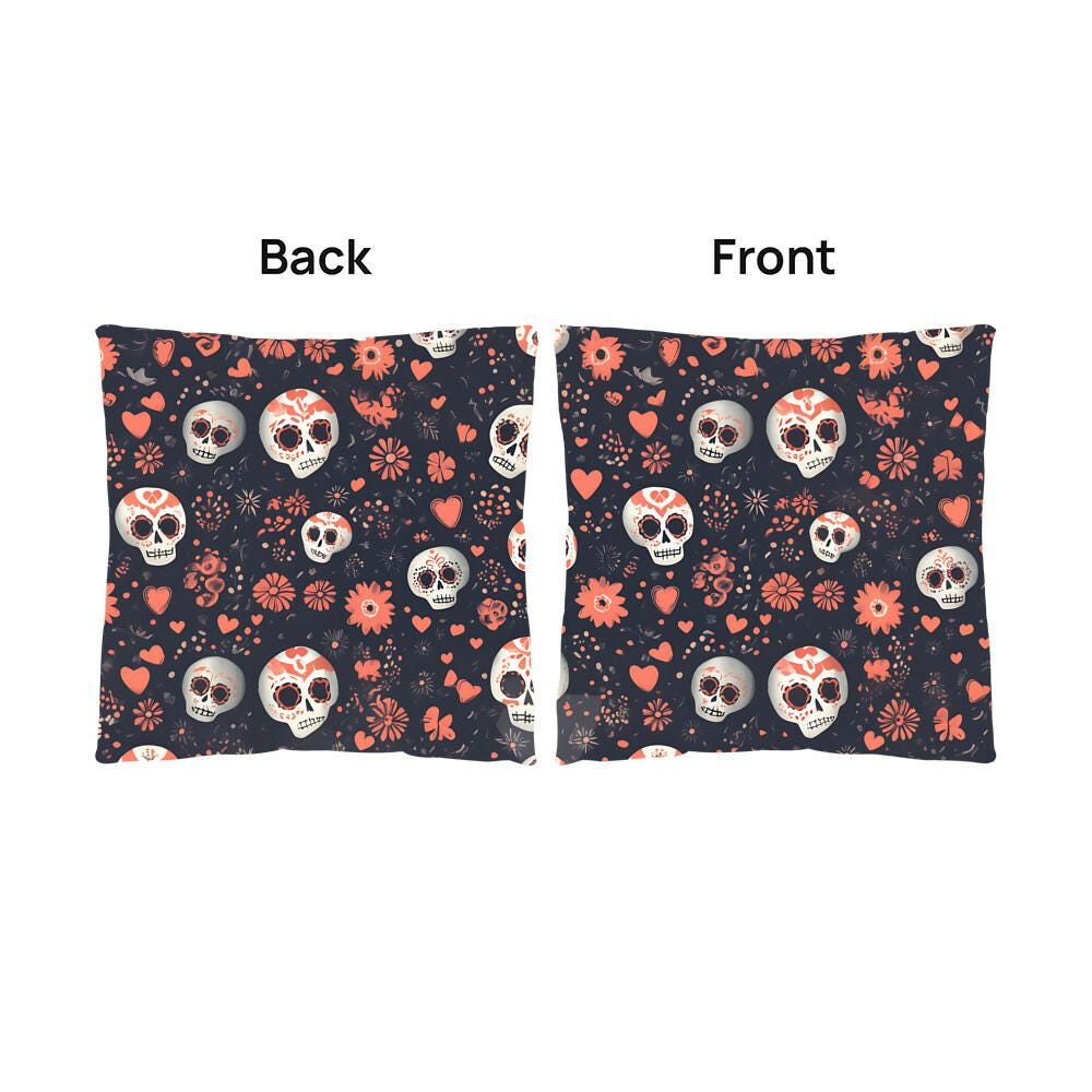 The Day of the Dead Mexican Skull Pillow boasts front and back views adorned with intricate sugar skull designs, flowers, and hearts set against a dark background. Ideal for infusing your home with goth decor or giving your Halloween decorations a unique flair.