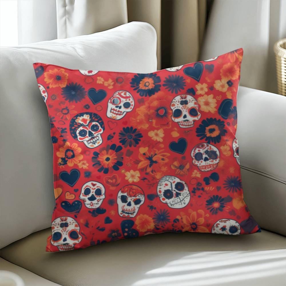 The Day of the Dead Mexican Skull Pillow, a Halloween gift embellished with vibrant floral and skull patterns popular in gothic home decor, showcases hues of orange, navy, and white. It sits stylishly on a beige sofa as a spooky decorative pillow for skull lovers.