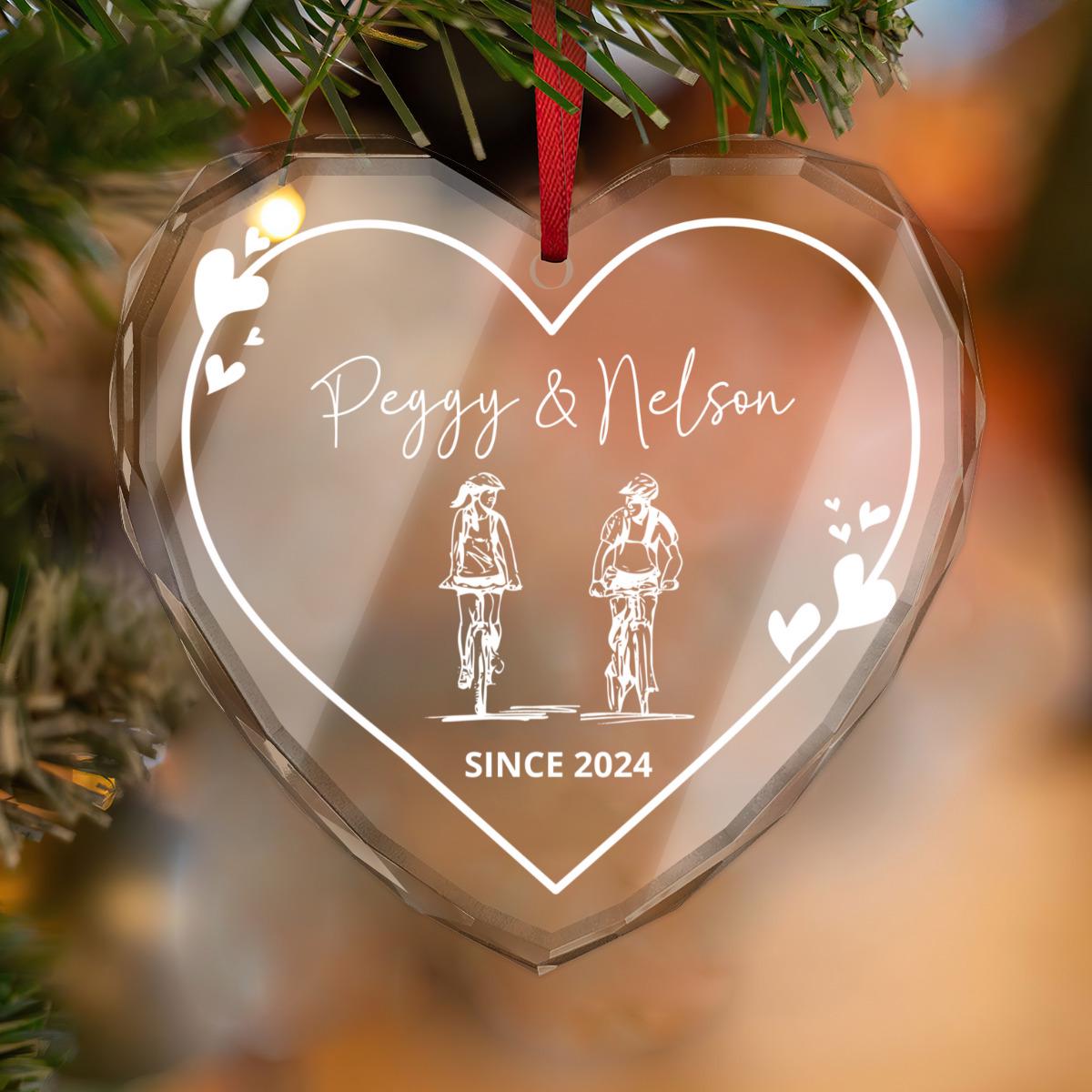The Custom Cyclist Couple GLASS Ornament features illustrations of two cyclists with "Peggy & Nelson" and "Since 2024." This personalized keepsake is perfect for commemorating a special bond.