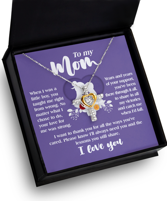 A "To Mom, Ways You've Cared(Boy) - Cross Dancing" necklace with a heart-shaped pendant inscribed with a sentimental message for a mother, presented in an open black box with a purple background.