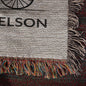The Personalized Life Is A Sweet Ride Cycling Couple Heirloom Woven Blanket is an ideal personalized gift, featuring a partially visible circular design with "ELSON" text. Its multicolored fringe enhances its charm as a cherished woven tapestry.