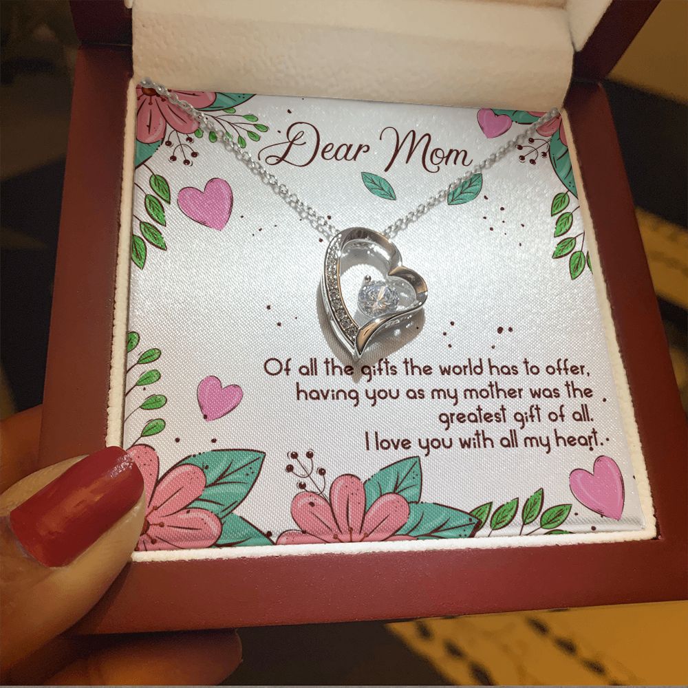 A woman holding a ShineOn Fulfillment necklace that says "To Mom - The Greatest Gift of All - Forever Love Necklace".