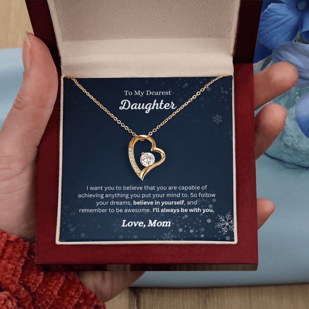 A woman holding a ShineOn Fulfillment Believe in Yourself Forever Love Necklace - Gift for Daughter from Mom in a box.