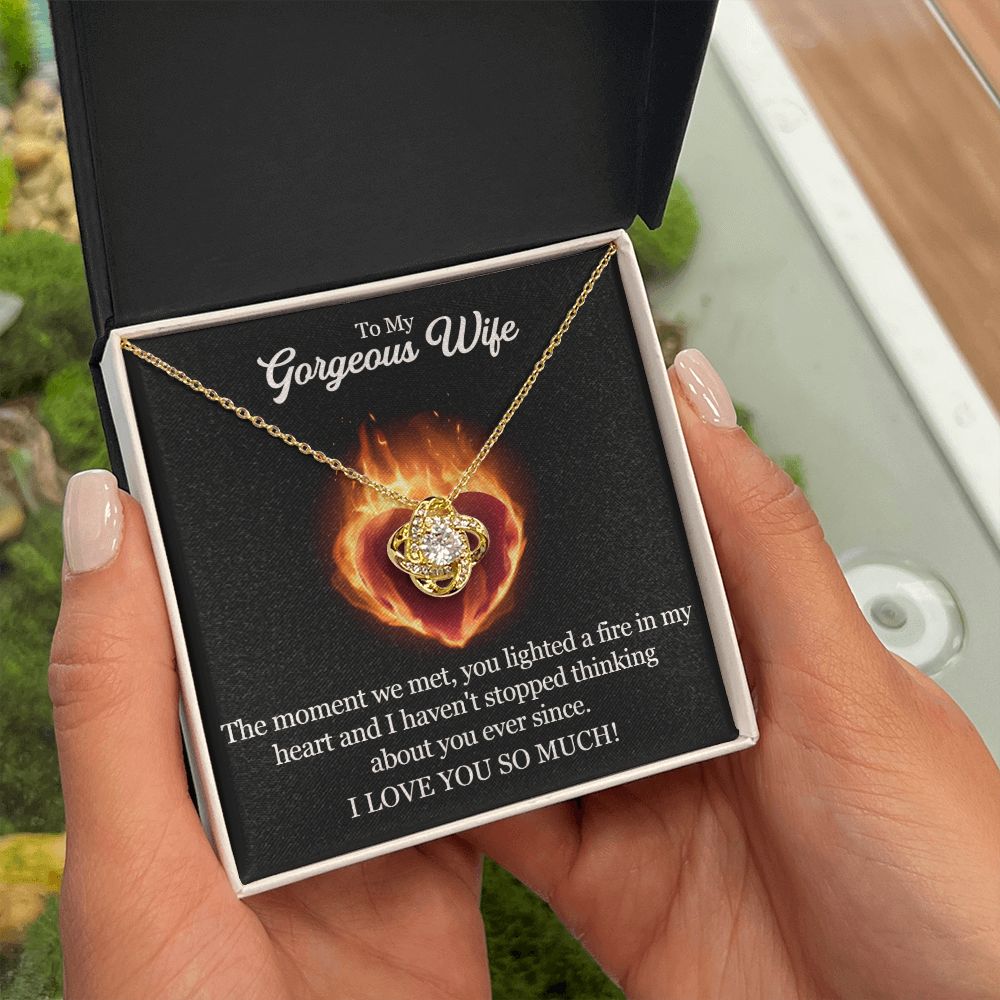 A woman is holding a ShineOn Fulfillment gift box with The Moment We Met Love Knot Necklace - To Wife from Husband that says i love you.