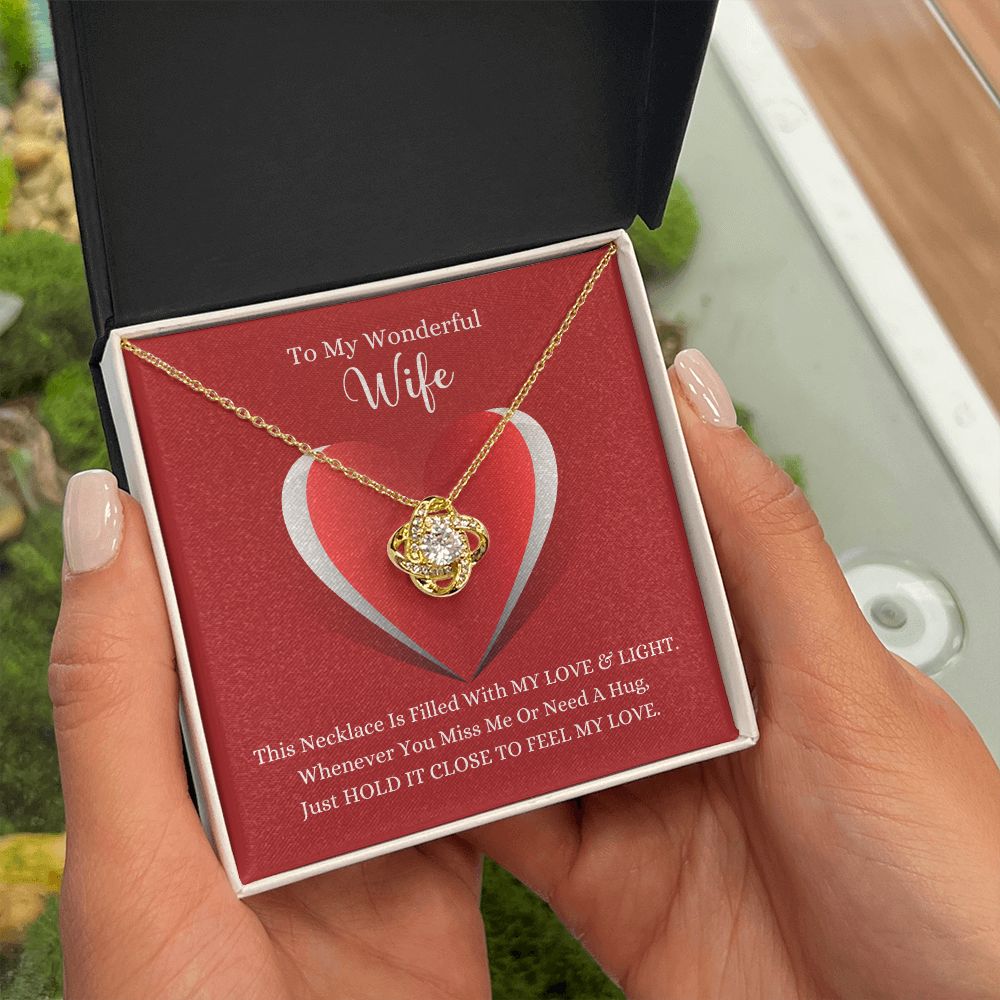 A woman holding a gift box with the ShineOn Fulfillment Love Knot Necklace - For Wife in it.
