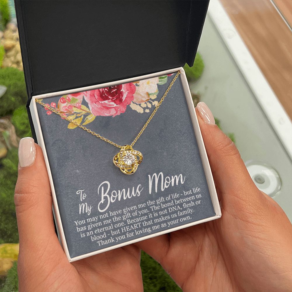 A person holding a ShineOn Fulfillment gift box with the Life Has Given Me The Gift of You Love Knot Necklace - For Bonus Mom inside.