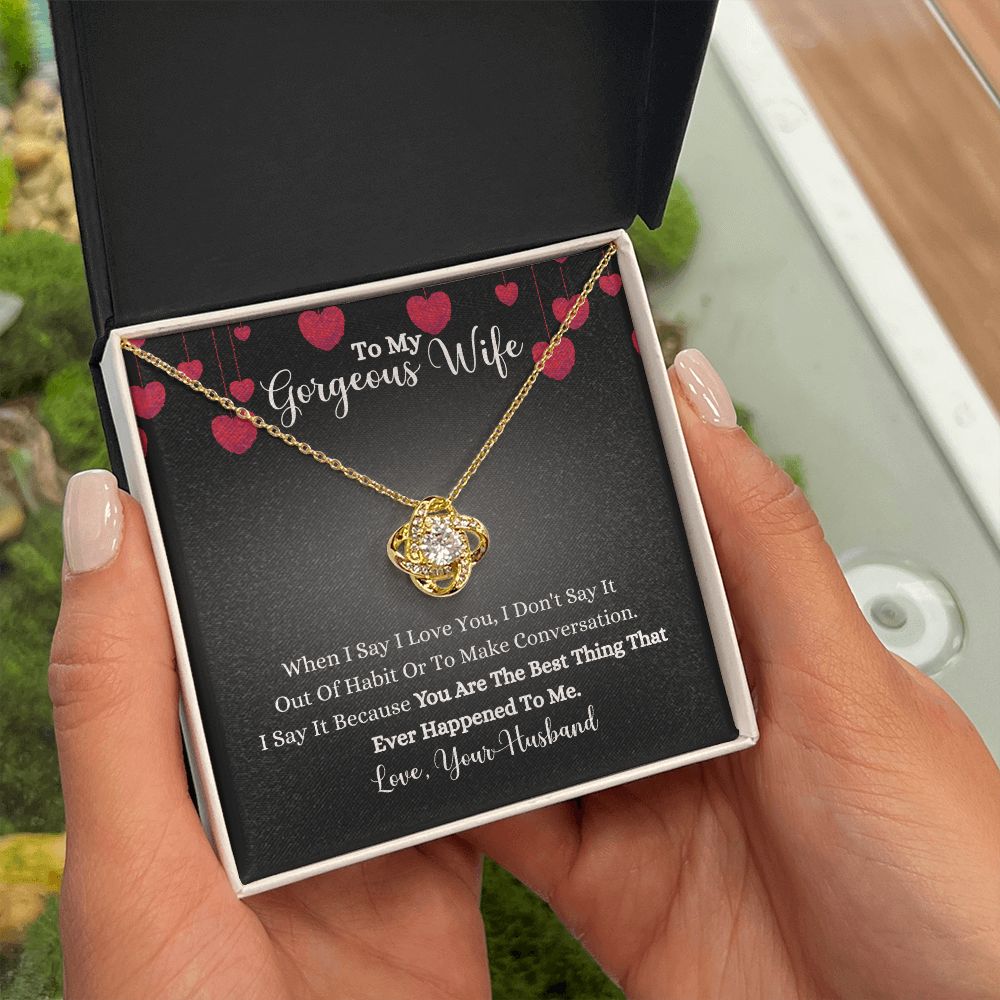 A person holding a gift box with the When I Say I Love You Love Knot Necklace - For Wife by ShineOn Fulfillment in it.