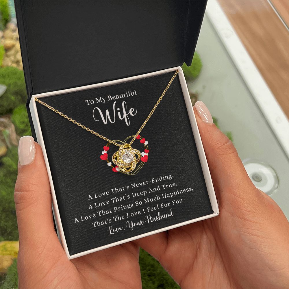 A woman holding a gift box with a A Love That's Never-Ending Love Knot Necklace - For Wife from ShineOn Fulfillment in it.