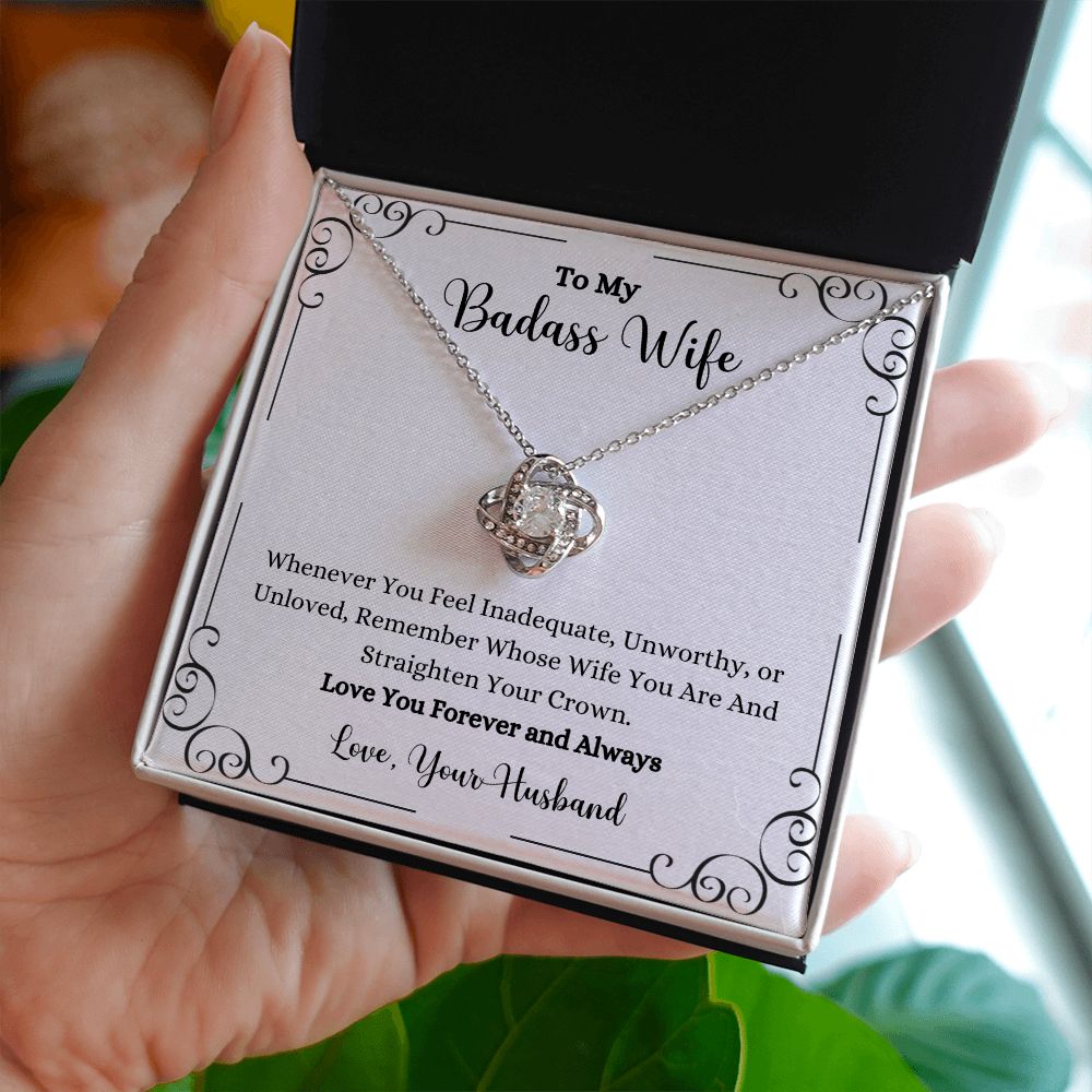 A woman is holding a ShineOn Fulfillment gift box with a Remember Whose Wife You Are Love Knot Necklace - Gift for Wife from Husband in it.