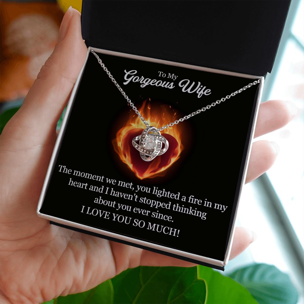 A woman holding The Moment We Met Love Knot Necklace - To Wife from Husband necklace, made by ShineOn Fulfillment, that says "I love you".