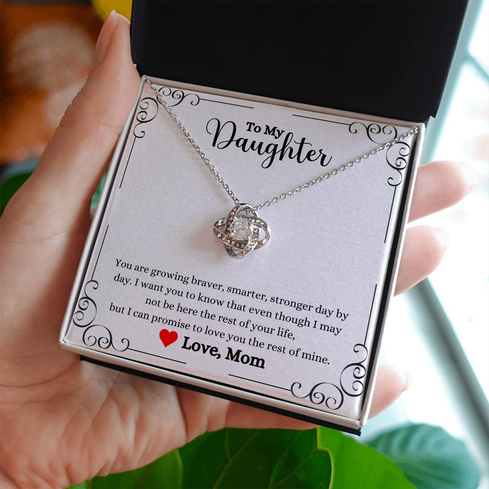 A woman holding a Love You The Rest of Mine Love Knot Necklace - Gift for Daughter from Mom necklace, made by ShineOn Fulfillment.