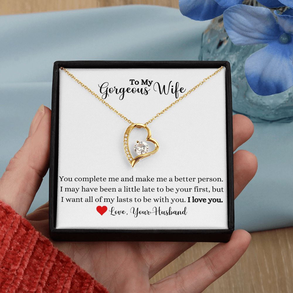 A woman holding a ShineOn Fulfillment necklace that says, "You Complete Me Forever Love Necklace - To Wife from Husband".