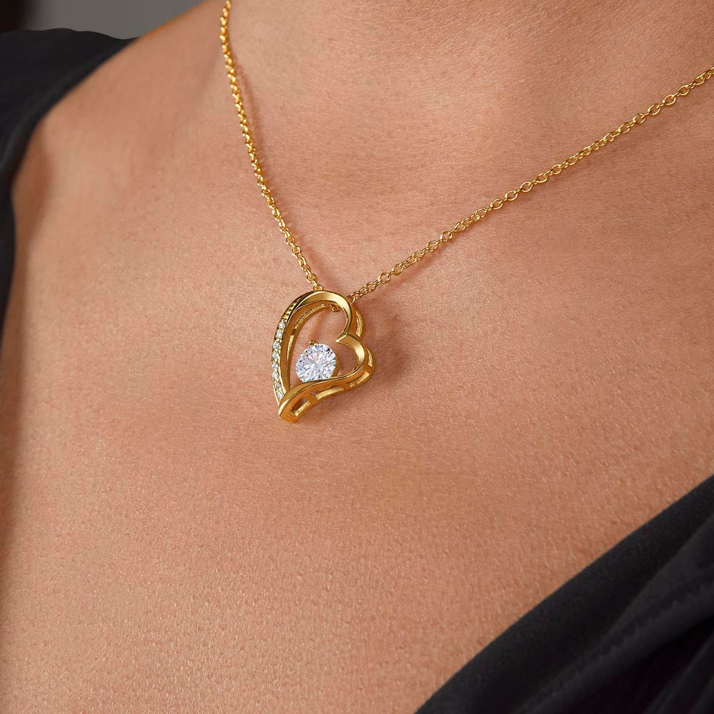 A woman wearing a I Love You Forever And Always Forever Love Necklace - For Daughter From Mom, designed by ShineOn Fulfillment, with a diamond heart pendant.