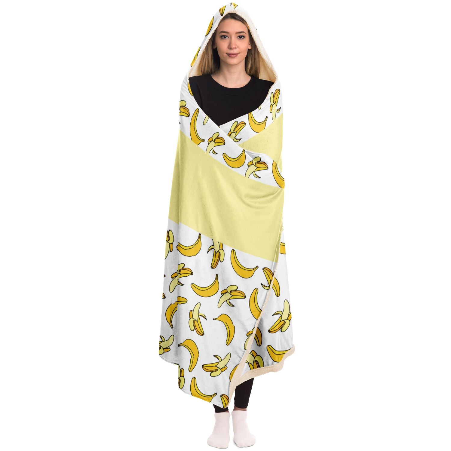 A woman snuggled up in a silky smooth Nana You're The Best Blanket Hoodie with Banana Pattern made of micro-mink polyester by Subliminator.