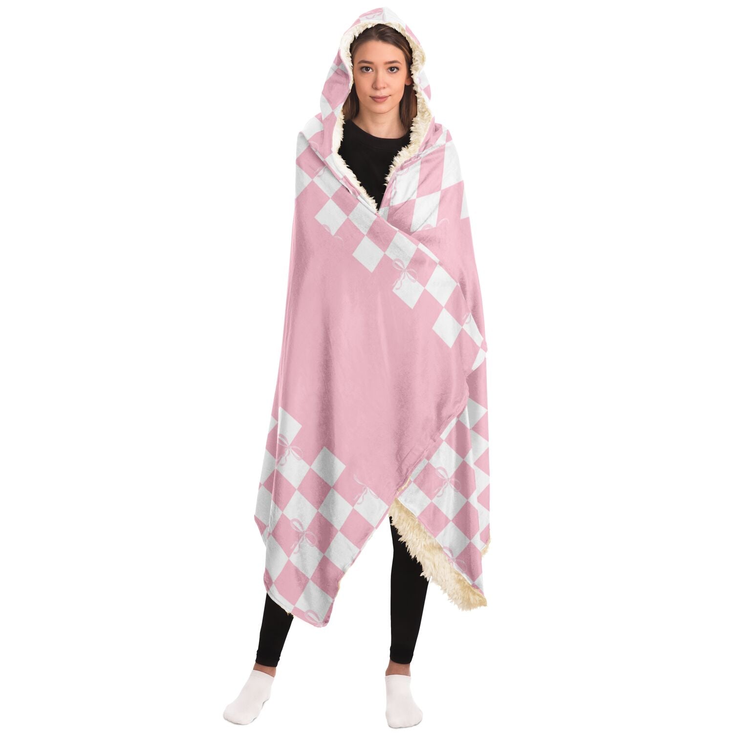 A woman cozily wrapped in a Subliminator Coquette Blanket Hoodie with Checkered Bow Pattern made of silky smooth micro-mink polyester face.