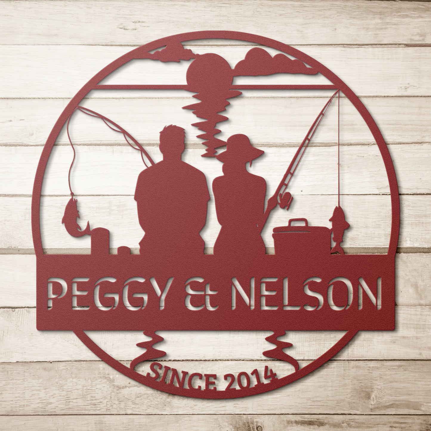 Introducing our Couple Fishing Together Metal Wall Art, crafted from 18-gauge steel and showcasing silhouettes of two people fishing. It is elegantly inscribed with "Peggy & Nelson" and "Since 2014," and mounted on a wooden background, making it the perfect addition to your home decor.