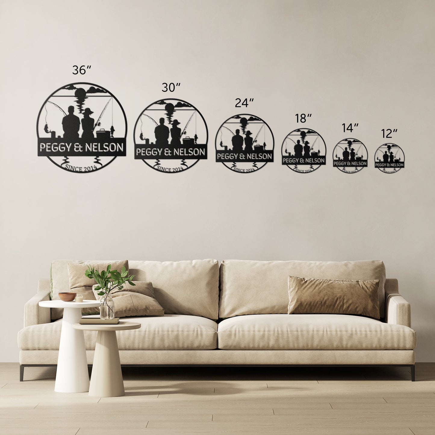 A living room with a beige sofa and a white round side table with a plant. Six wall signs made from 18-gauge steel, each in different sizes, add a unique touch to the home's decor. The Couple Fishing Together Metal Wall Art elegantly displays the text "PEGGY & NELSON" on a metal sign above the sofa.