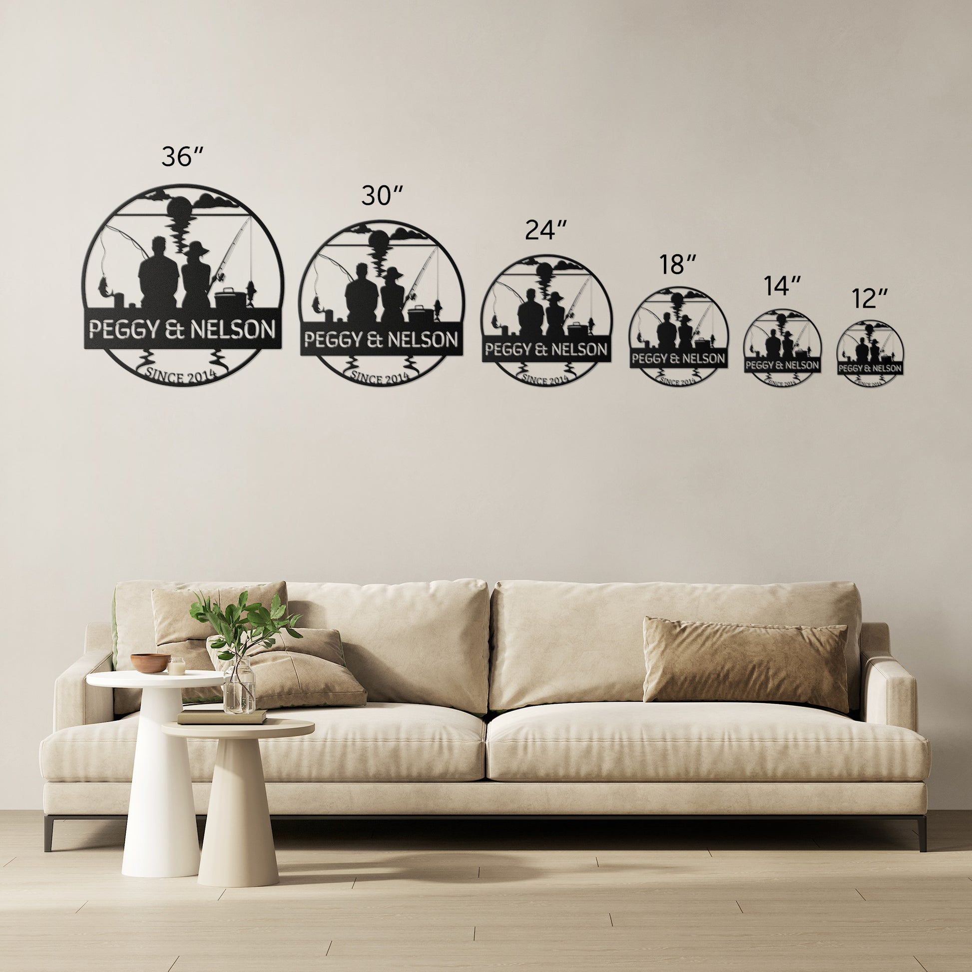 A living room with a beige sofa and a white round side table with a plant. Six wall signs made from 18-gauge steel, each in different sizes, add a unique touch to the home's decor. The Couple Fishing Together Metal Wall Art elegantly displays the text "PEGGY & NELSON" on a metal sign above the sofa.