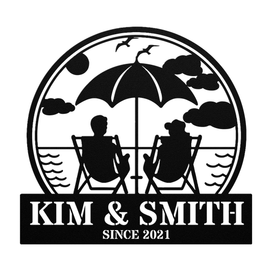 Silhouette of two people sitting under an umbrella by the sea with clouds and birds overhead. The stylish "Couple Relaxing On The Beach Metal Wall Art" adds a touch of elegance to your home decor, featuring a chic "Kim & Smith Since 2021" inscription.