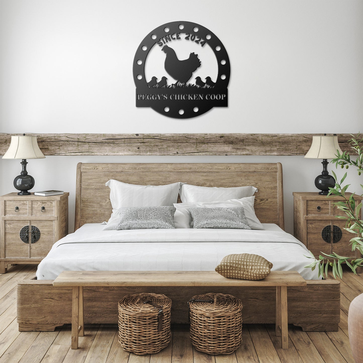 A bedroom featuring a wooden bed, rustic side tables, and lamps. Above the bed hangs a "Custom Chicken Coop Metal Sign" bearing the phrase "Since 2017 Peggy's Chicken Coop" adorned with a chicken design. Basket storage beneath the bench enhances the delightful home decor.