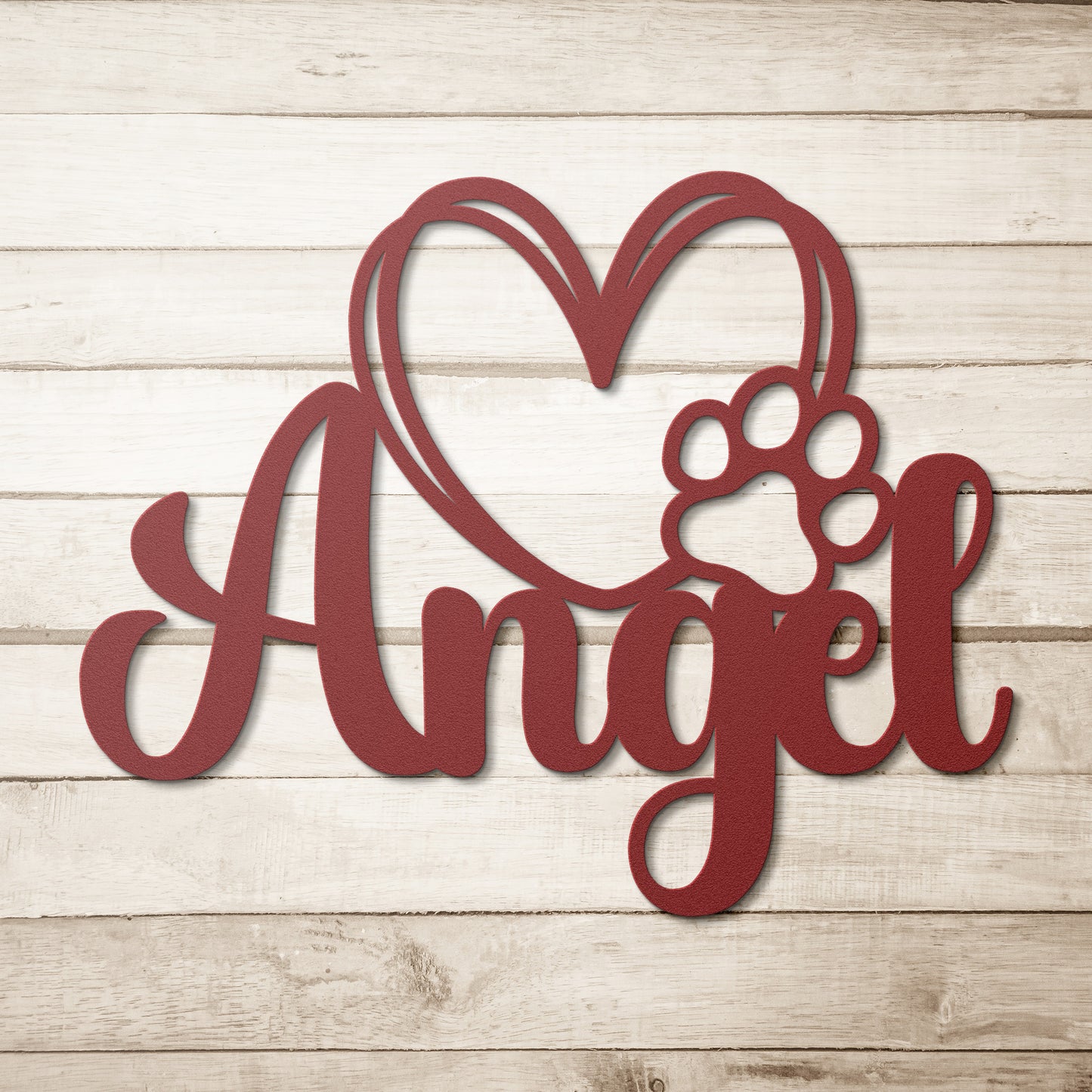 A wooden door with a glass panel in the center is set in a brick wall. To the left of the door is a potted plant with white flowers, and an 18 gauge steel sign that reads "Angel" with a heart and pawprint adds charm to the home decor. This unique touch is provided by the Custom Pet Name Metal Sign with Heart and Paw.