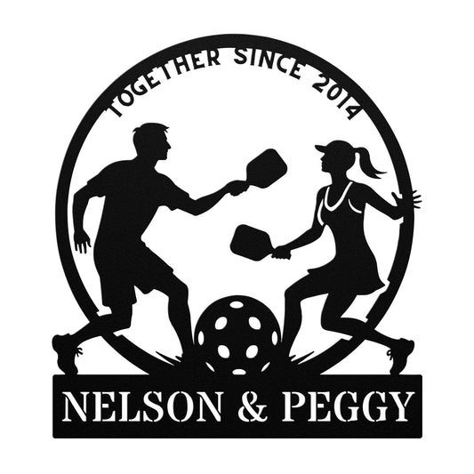 Depicted is a custom pickleball lovers metal art made from 18 gauge steel, featuring the silhouette of a man and woman playing pickleball within a circle. The text above says "Together Since 2014," while below it reads "Nelson & Peggy." This piece is an ideal gift for couples, adding charm and sentiment to any home decor.