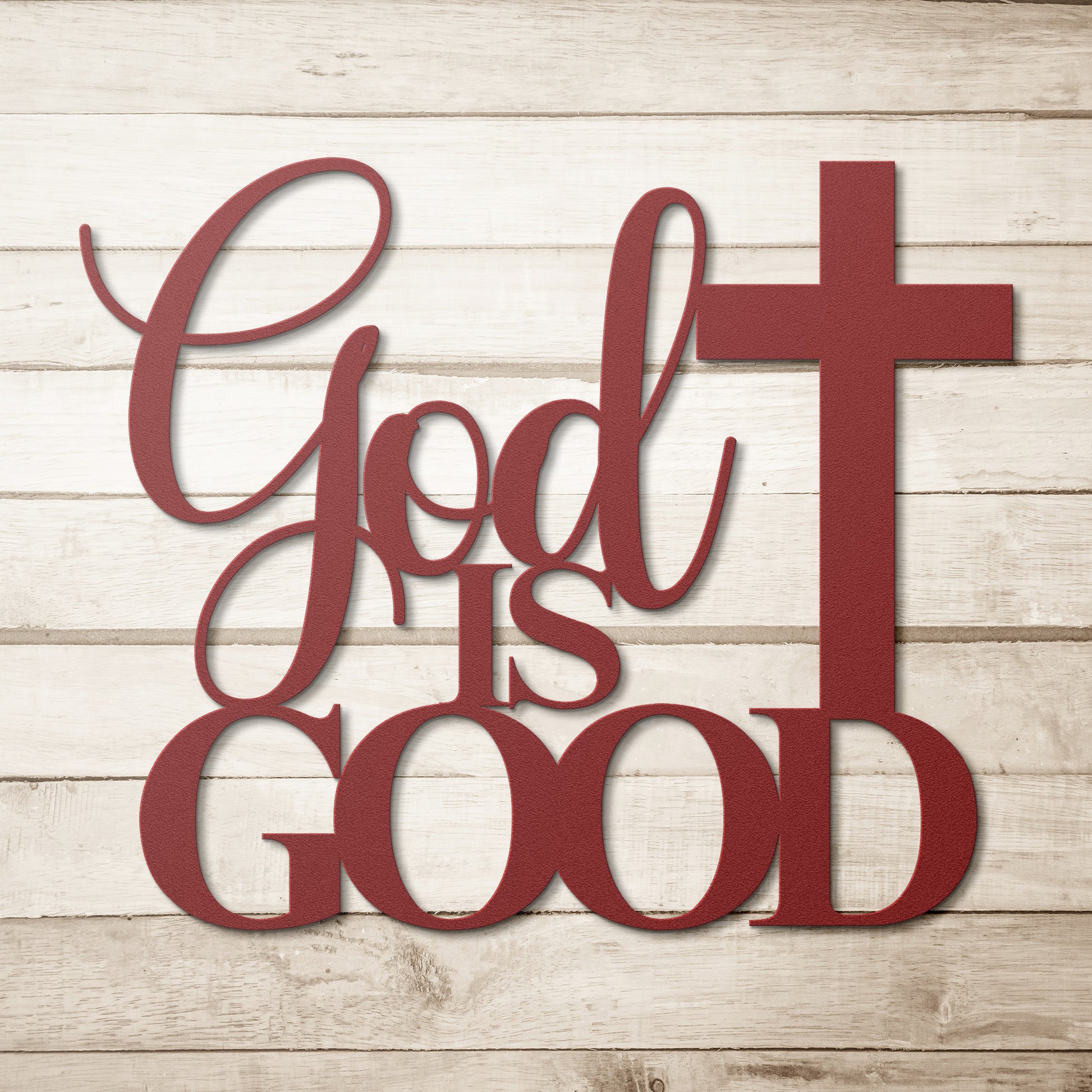 A brown wooden door with decorative glass is set in a brick wall. A potted plant sits beside it, and a stylish powder-coated sign "God Is Good Christian Metal Art" next to a cross enhances the decor. A black outdoor lamp hangs above the sign, completing the charming home decor scene.
