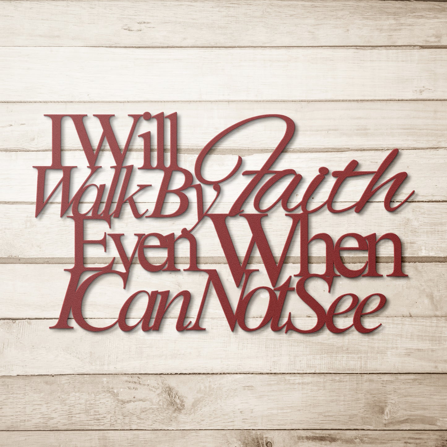 A wooden front door with a decorative glass panel is framed by bricks. A potted plant sits on the left, and an outdoor light hangs above. On the wall, a sign made of 18 gauge steel reads, "I Will Walk By Faith Even When I Cannot See," showcasing the Christian Metal Art piece.