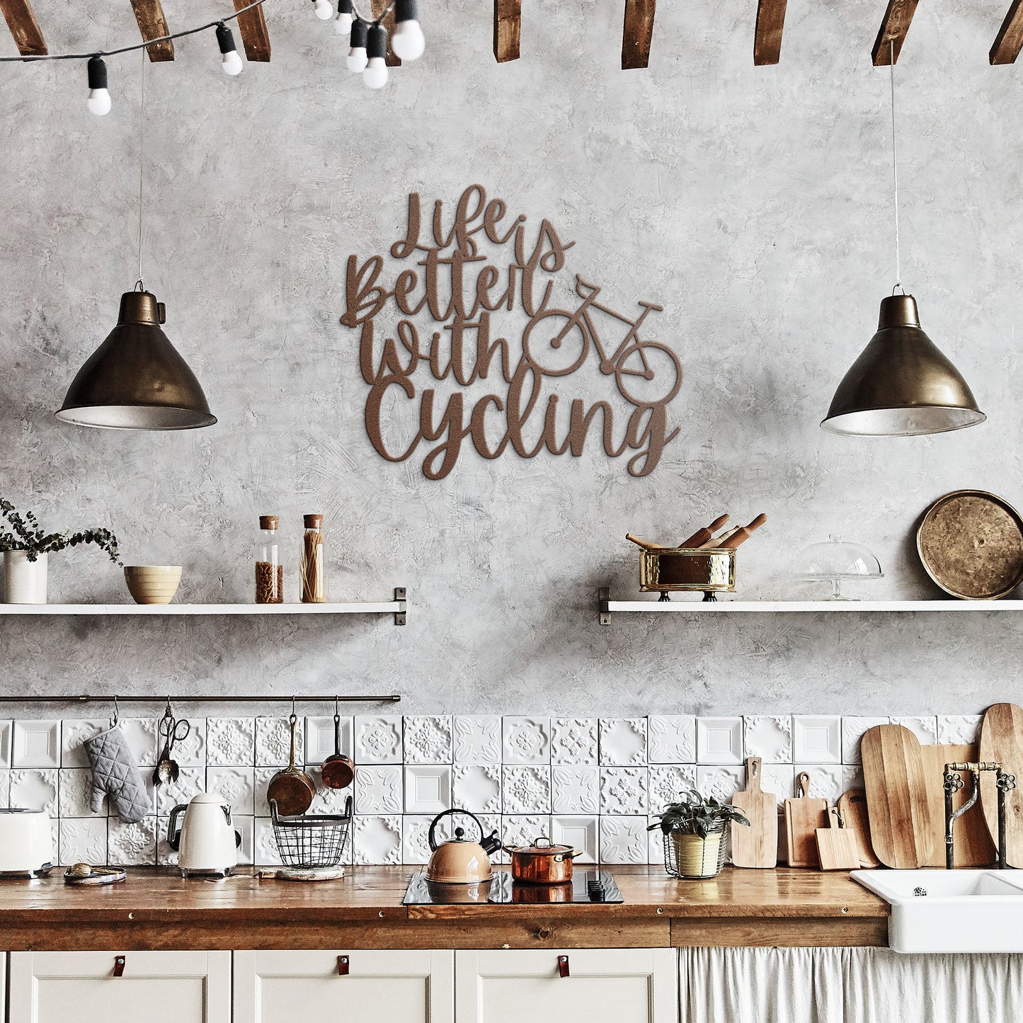 A brick wall with a wooden door, a potted plant, a black outdoor light, and the "Life is Better with Cycling Metal Sign - Road Bike Edition," reading "Life's Better with Cycling" alongside a bicycle graphic, perfect for stylish home decor.