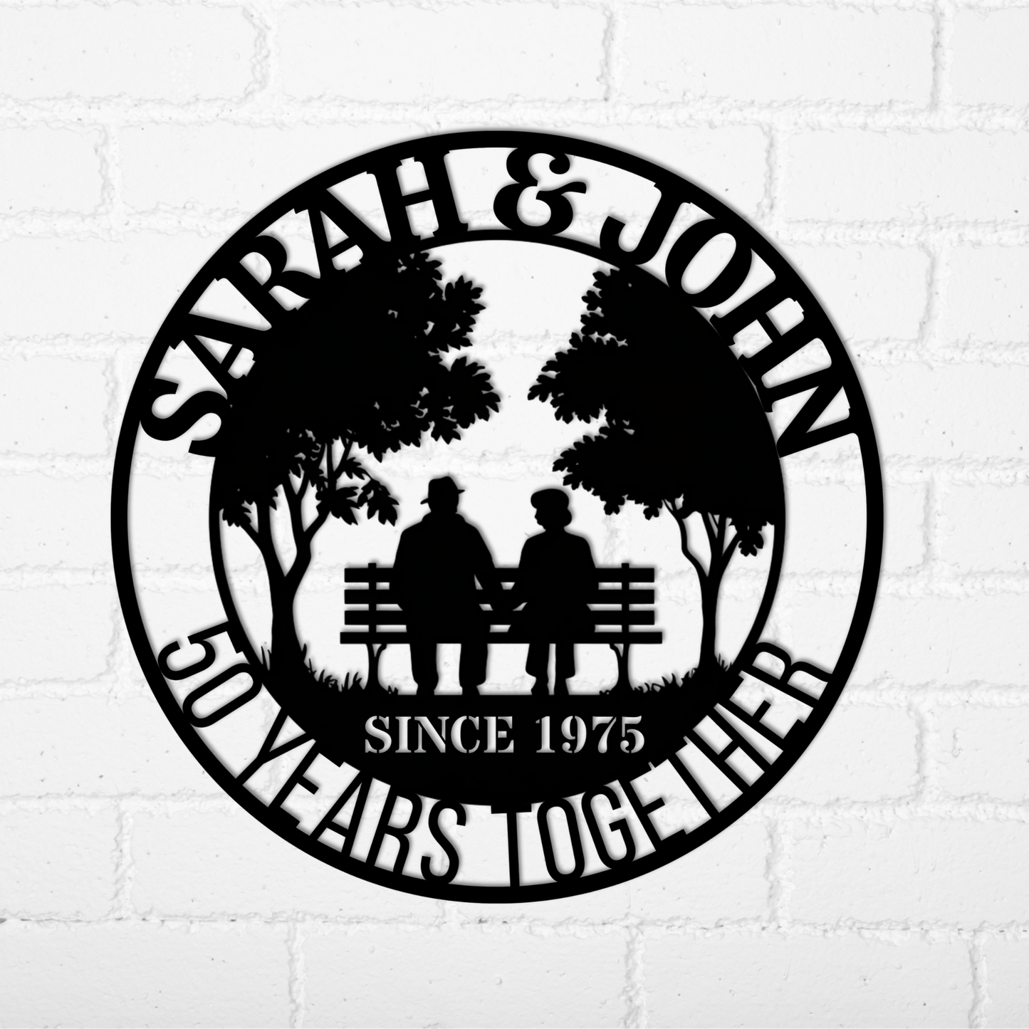 Personalized 50th Wedding Anniversary Metal Wall Art—custom black metal sign showing two people on a bench under trees, with “SARAH & JOHN” above and “50 YEARS TOGETHER SINCE 1975” below. Perfect for unique anniversary decor.