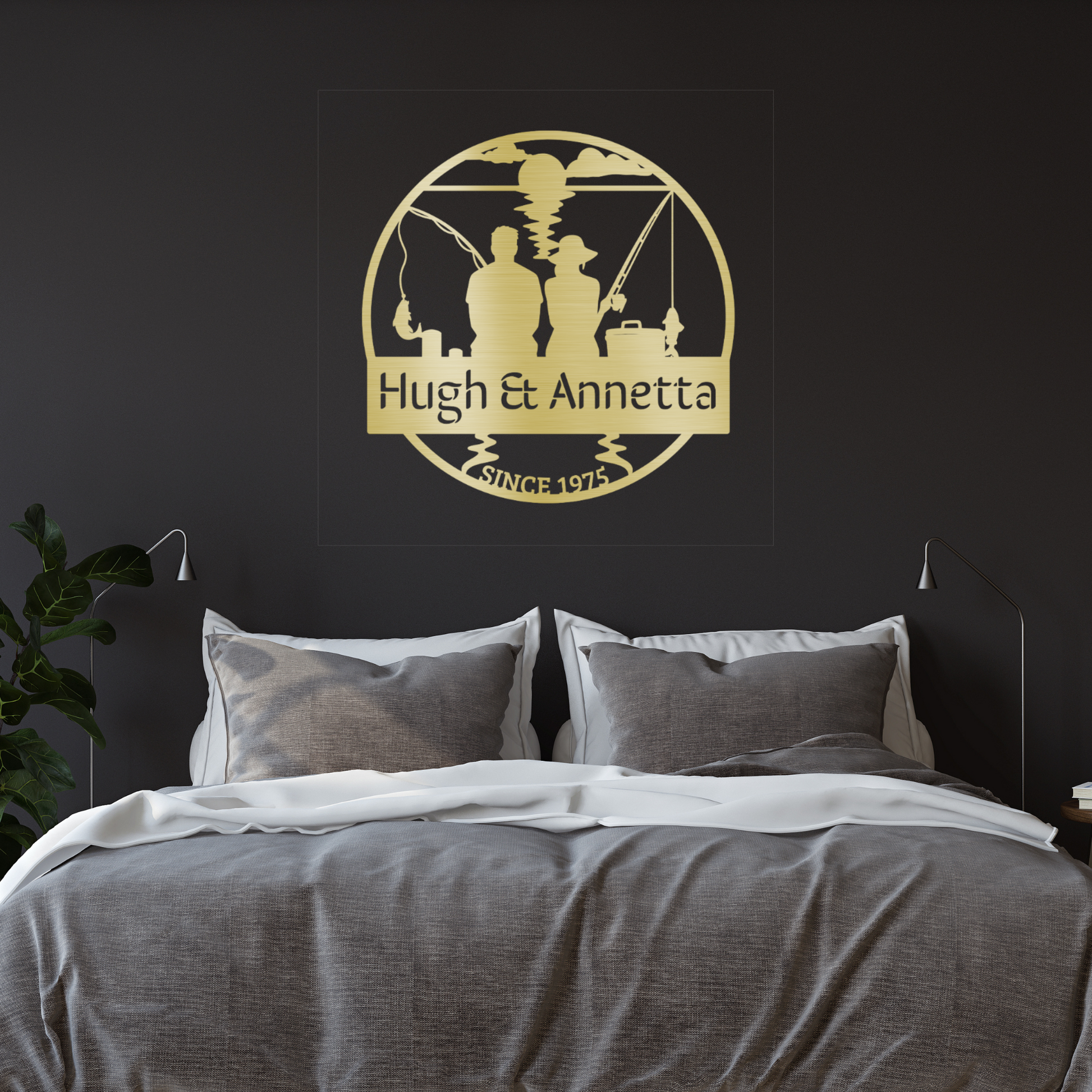 A cozy bedroom with gray and white bedding features a plant and a Custom Fishing Couple Metal Sign above the bed, personalized with "Hugh & Annetta" and "Since 1975," making it a perfect fishing anniversary gift.