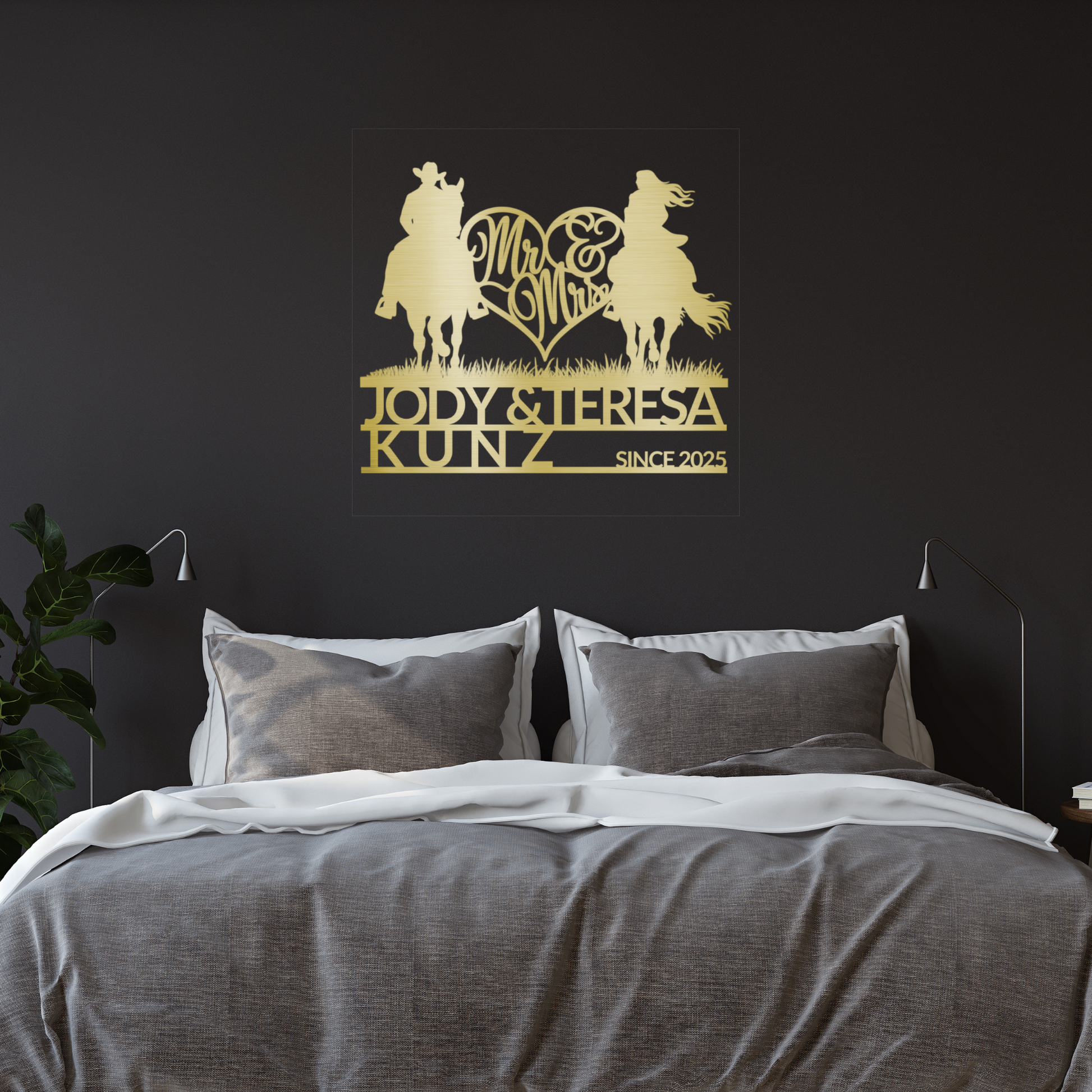 A cozy bed with gray and white bedding sits against a dark wall, above which hangs the Personalized Mr & Mrs Horse Riding Metal Sign, featuring two riders, "Mr & Mrs," and "Jody & Teresa Kunz, Since 2025.