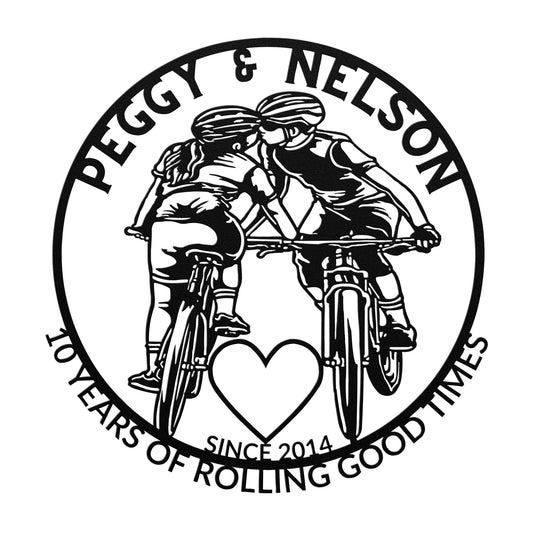 A depiction of two cyclists kissing, encircled by the text: "Peggy & Nelson, 10 Years of Rolling Good Times, Since 2014," with a heart symbol in the center. This personalized cycling couple on mountain bikes metal art makes an ideal gift for any bicycle-loving couple celebrating an anniversary.