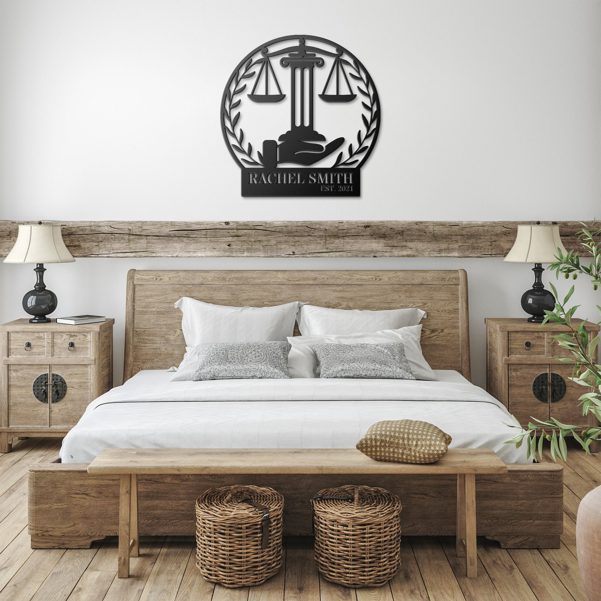 A brick exterior wall with a wooden door featuring an arched window. Beside the door, a black metal sign with a "Scales of Justice" design reads "Rachel Smith." A potted plant with white flowers sits next to the door, adding a touch of home decor.