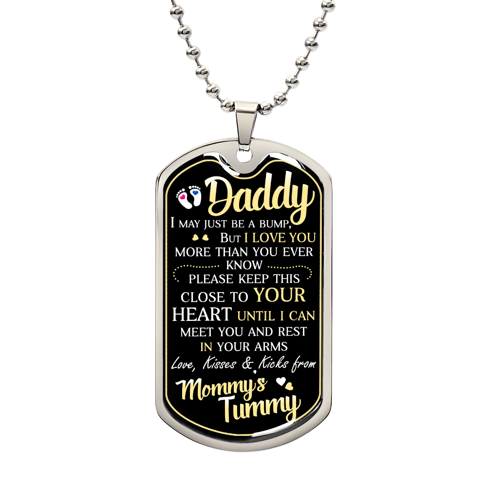 Pendant with "To Daddy, I May Just Be A Bump" message from an unborn baby to their father, featuring custom engraving and small graphics on a black background, suspended from a surgical steel chain.