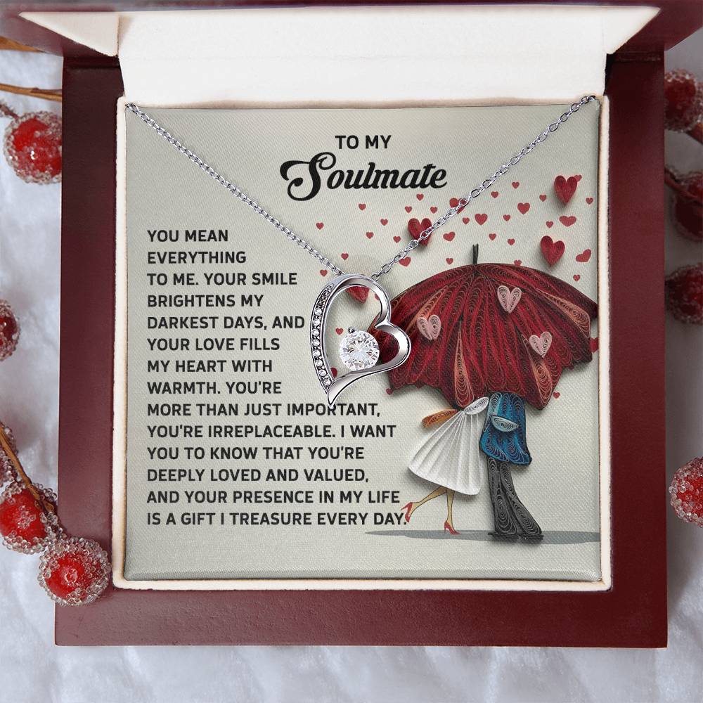 The Soulmate-Deeply Loved - Forever Love Necklace, featuring a CZ crystal and white gold finish, is elegantly presented in its box with a heartfelt message card and decorative red berries.