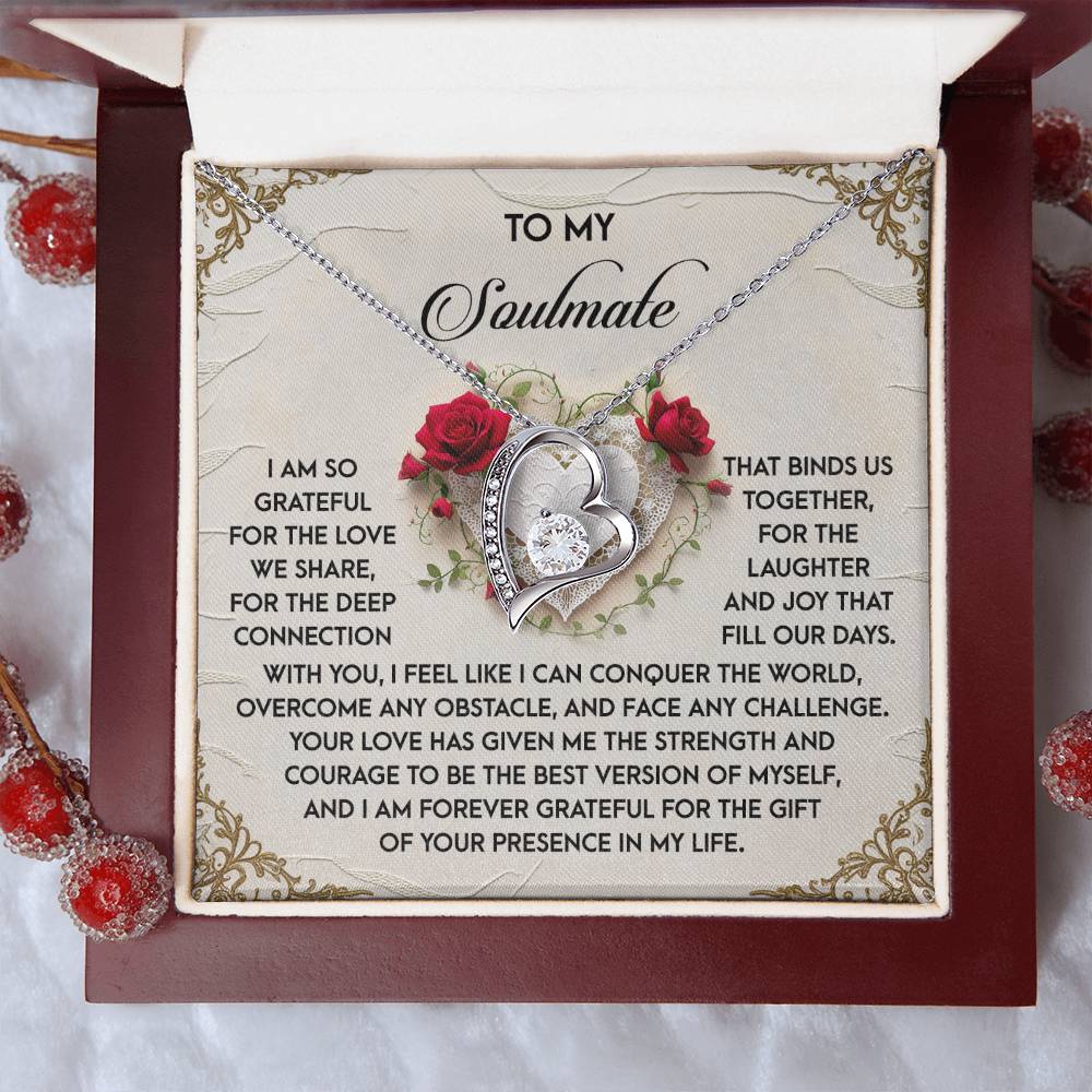 An open gift box reveals the Soulmate-Our Days - Forever Love Necklace with a heart-shaped pendant, enhanced by stunning CZ crystals. The background showcases a romantic message and decorative red roses, complementing the white gold finish's charm.