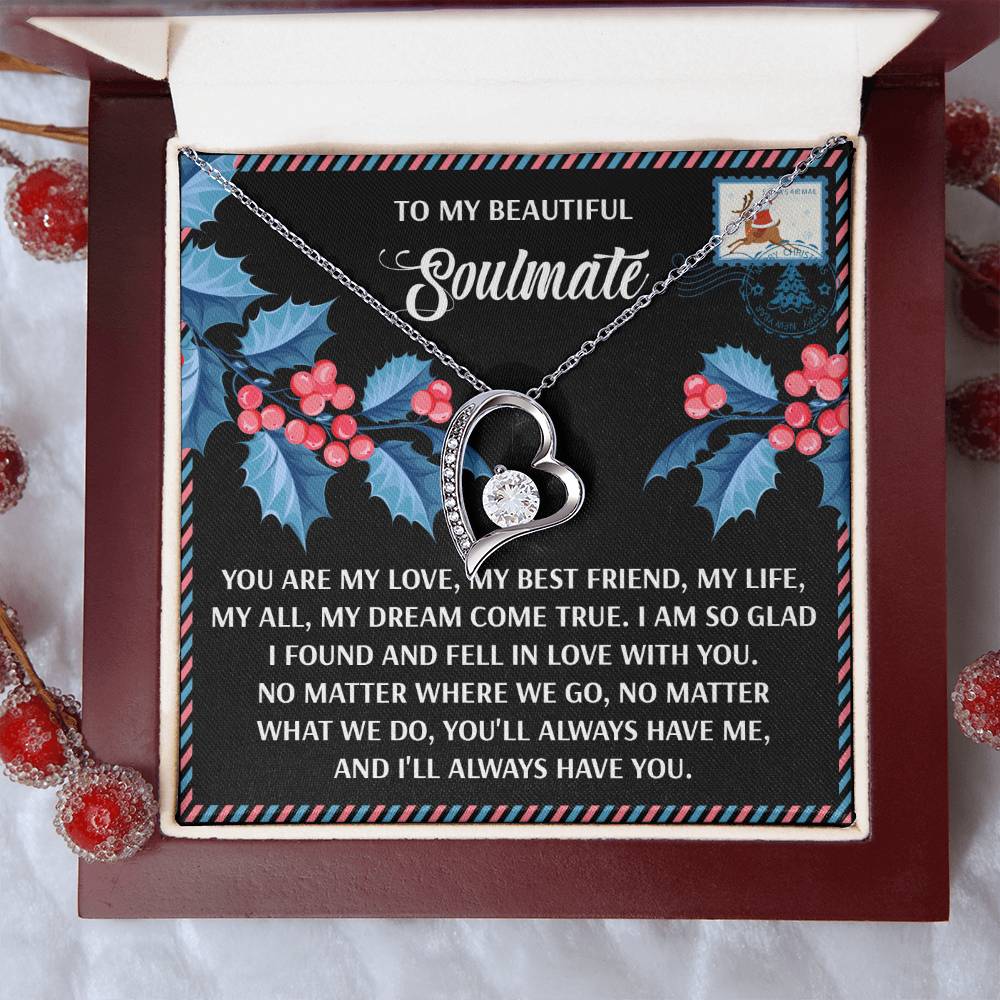 The Soulmate-Fell In Love - Forever Love Necklace, featuring a heart pendant in an open gift box with a soulmate message on the inside lid, is surrounded by festive decorations, making it the perfect personalized gift.