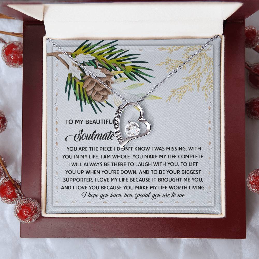 The Soulmate-Biggest Supporter - Forever Love Necklace, featuring a heart-shaped pendant with a gold finish, is elegantly displayed in a box containing a heartfelt message. Adorned with pine cone and branch decor, its cubic zirconia shines brilliantly against the backdrop.