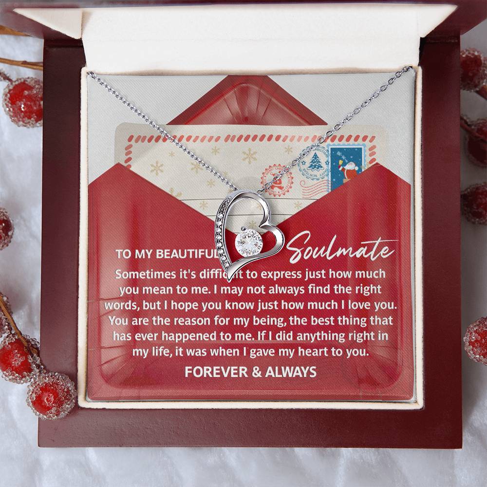 The Soulmate-Right Words - Forever Love Necklace, featuring a heart-shaped design with a gold finish, rests in an open gift box and is complemented by a heartfelt message about love and devotion. It is adorned with sparkling CZ crystals.