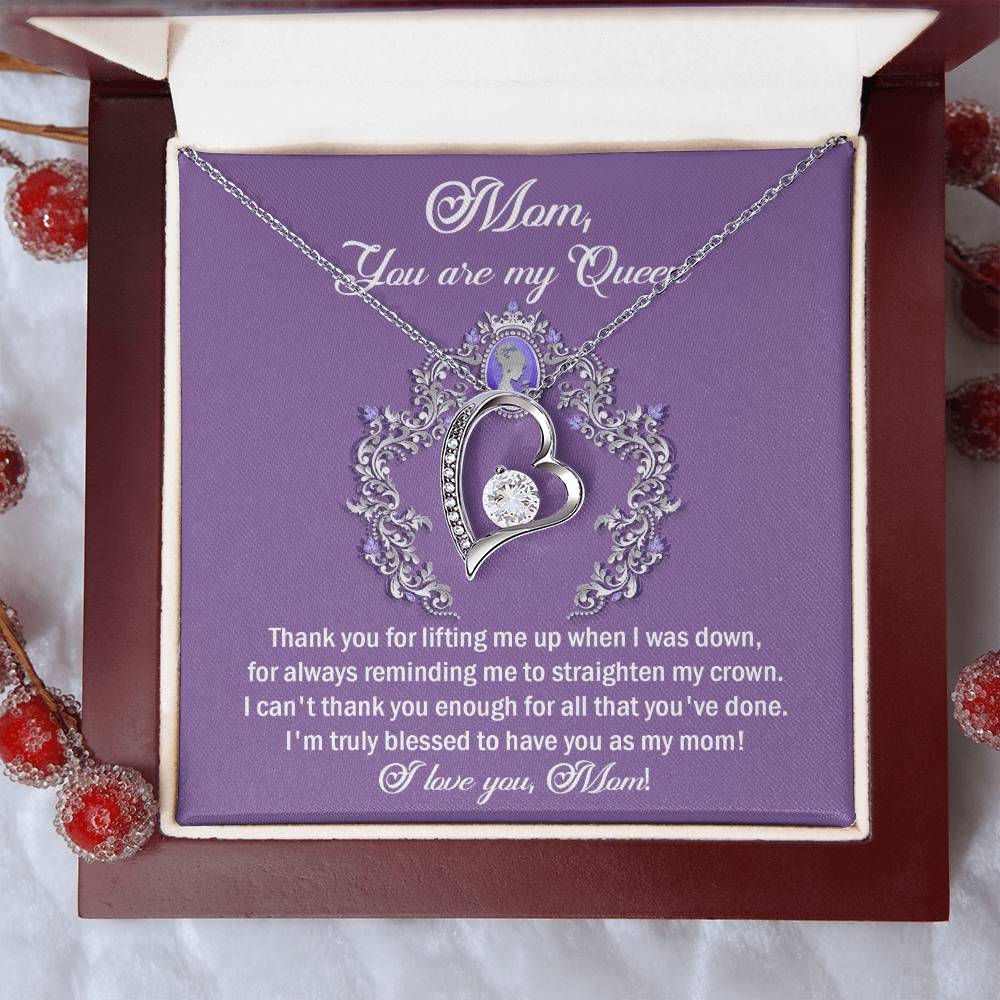 The "To Mom, Belongs To Me - Forever Love Necklace" is a silver heart pendant adorned with cubic zirconia, presented in a stylish purple gift box that features the heartfelt message, "Mom, You are my Queen," along with grateful sentiments.