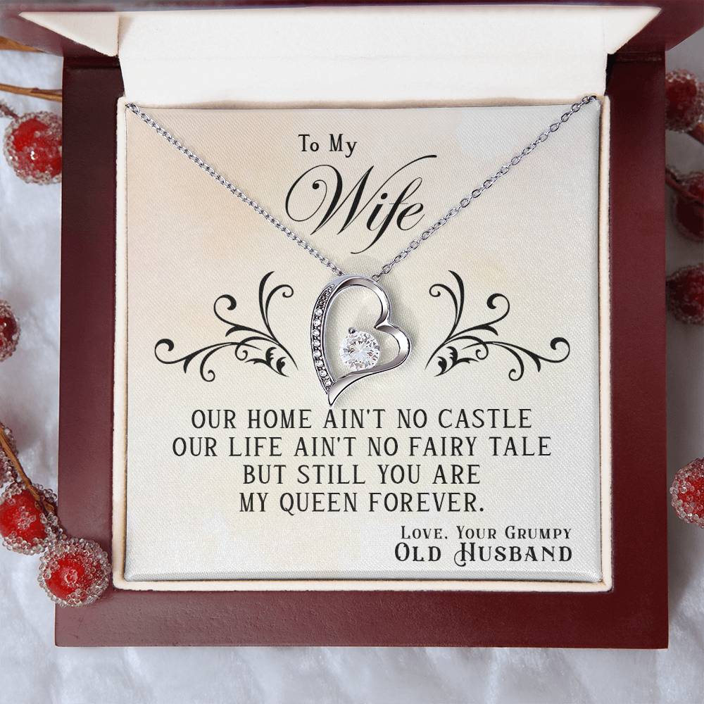 A gold finish, heart-shaped To My Wife, You Are My Queen Forever - Forever Love Necklace from ShineOn Fulfillment inside a gift box with a sentimental message for a wife from her husband.