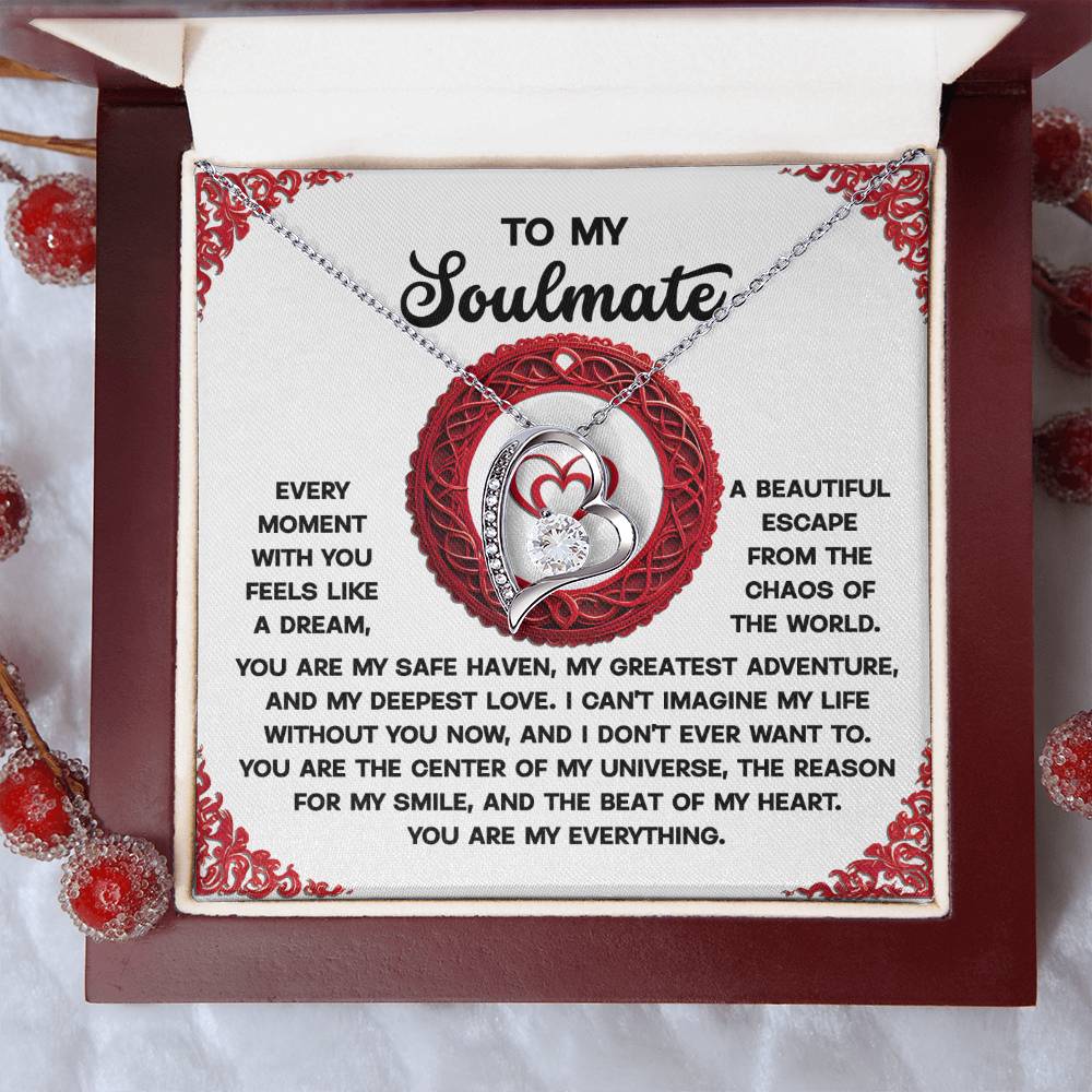 The Soulmate-Like A Dream - Forever Love Necklace, with a white gold finish and cubic zirconia stones, features intertwined heart and infinity symbols. Packaged in a box with red berries, it includes a heartfelt message expressing love and appreciation to your soulmate.