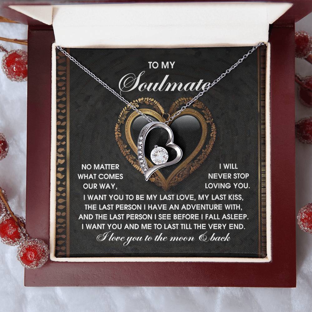 The Soulmate-The Very End Forever Love Necklace, featuring a heart-shaped pendant with cubic zirconia stones, rests gracefully in an open box with a touching message about love and companionship, surrounded by decorative berries.